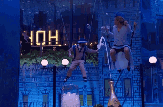 a man on a swing is holding a bottle of champagne