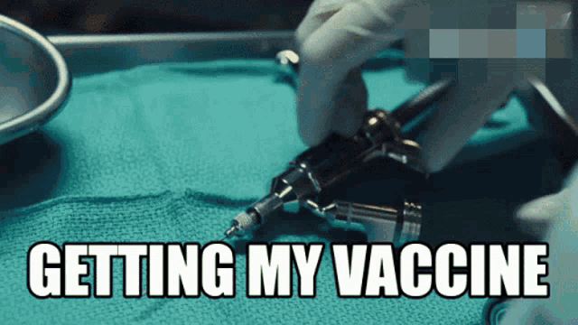 a person is getting their vaccine with a syringe in their hand