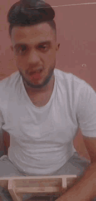 a man with a beard is looking at himself in a mirror with blood on his face .