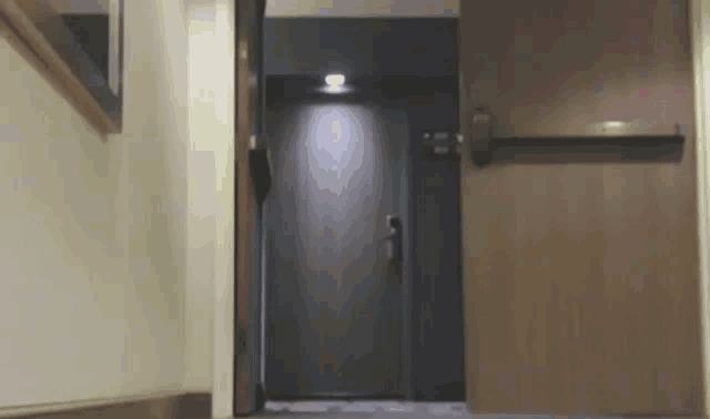 a hallway with a door that is open and a mirror on the wall