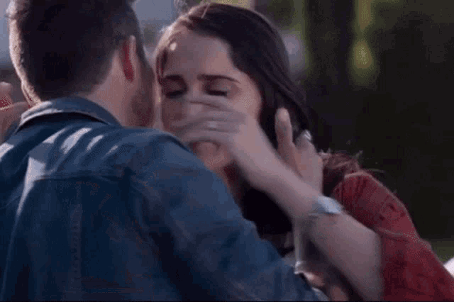 a man and a woman hugging in front of a car