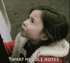 a little girl in a red jacket is looking up at something while holding a piece of paper .