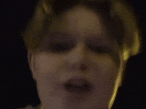 a close up of a person 's face with their eyes closed in the dark .