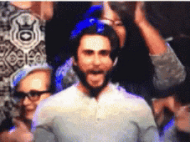 a man with a beard wearing a blue helmet is surrounded by people