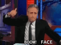 a man in a suit and tie is giving a thumbs up and says boom face .