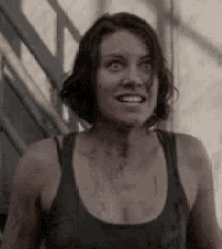 a woman in a tank top with blood on her chest is smiling and looking at the camera .