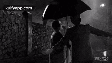 a man is holding an umbrella over a woman .