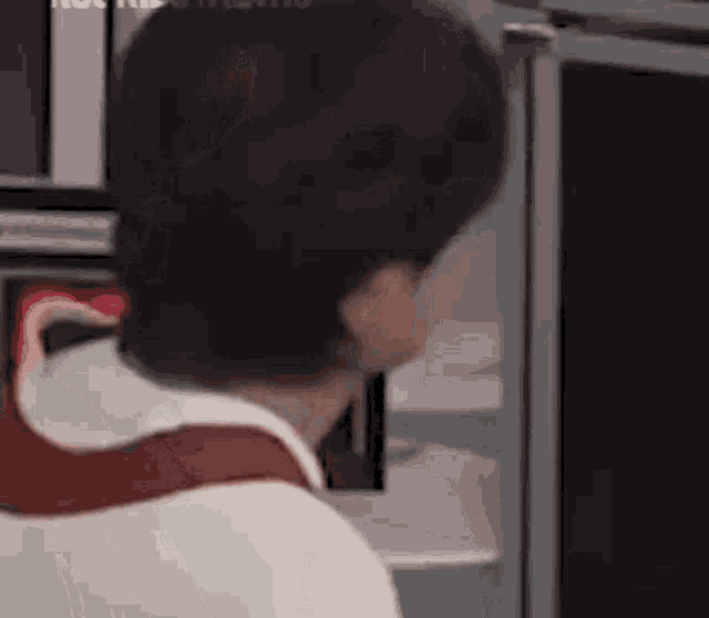 a man is sitting in front of a computer monitor looking at something .