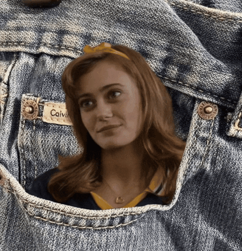 a woman in a calvin klein shirt is sticking her head out of a pocket