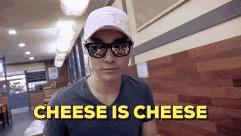 a man wearing sunglasses and a hat says cheese is cheese in a restaurant