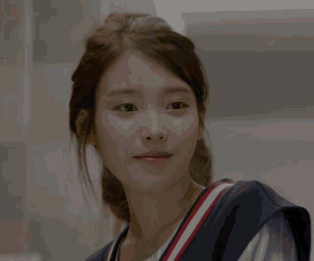 a close up of a woman 's face with a striped vest