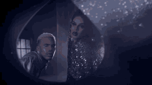 a man and a woman are looking at each other through a mirror