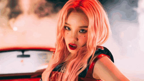 a woman with pink hair is standing in front of a car