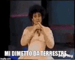 a woman is singing into a microphone with the words `` mi dimetto da terrestre '' written on the screen .