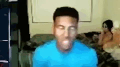 a blurry picture of a man in a blue shirt with his mouth open