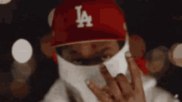 a man wearing a red la hat and a white face mask