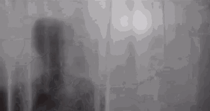 a silhouette of a person is behind a shower curtain .