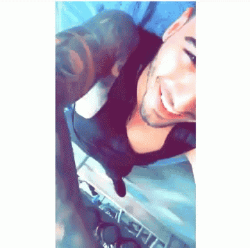 a man with a tattoo on his arm is smiling