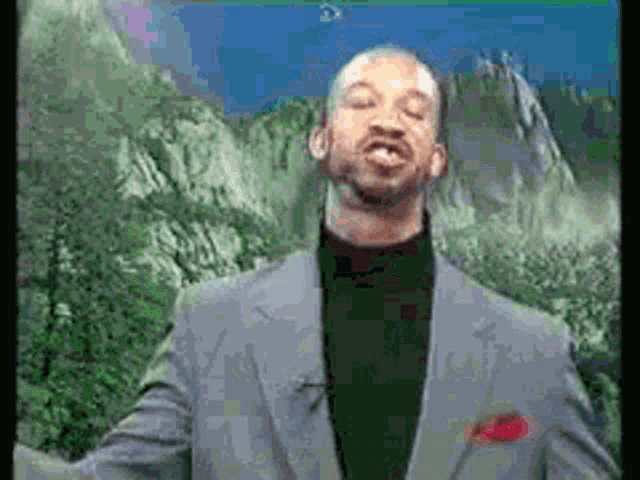 a man in a suit stands in front of a mountain