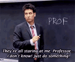 a man in a suit and tie stands in front of a blackboard that says prof