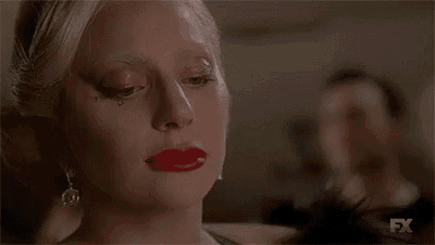 a woman with red lipstick is crying with a tear running down her face .
