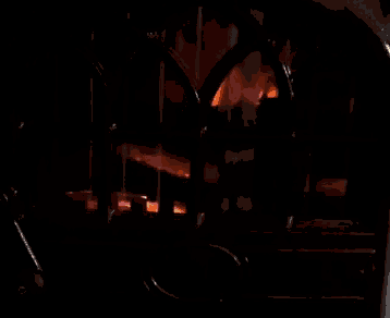 a fire is burning in a fireplace with a black grille
