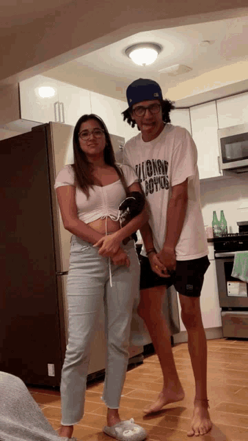 a man wearing a t-shirt that says ' aloha ' on it stands next to a woman
