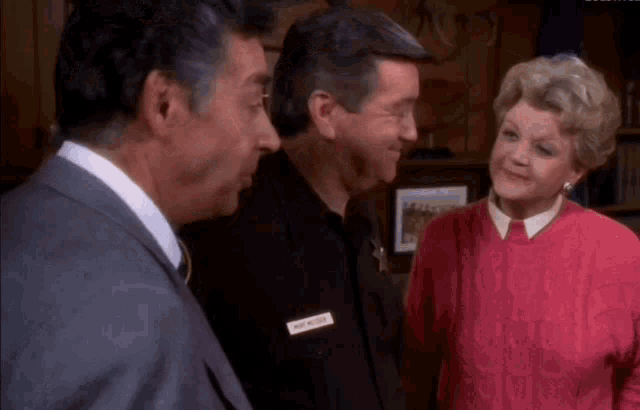 a woman wearing a pink sweater has a name tag that says mike