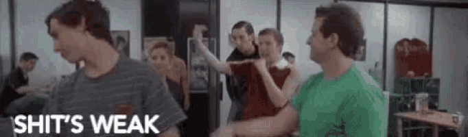 a group of people are standing in a room with the words `` shit 's weak '' on the bottom .
