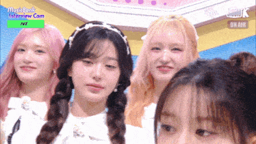a group of girls are standing in front of a music bank interview cam