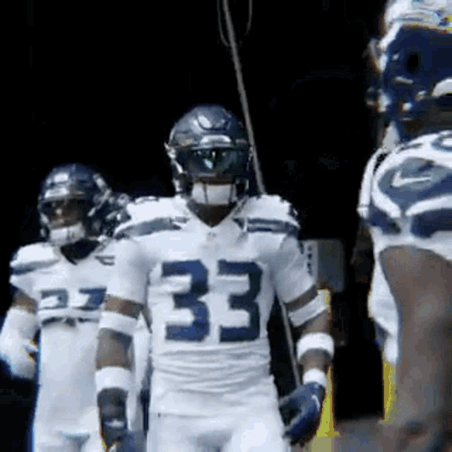 a group of football players are standing in a dark room .