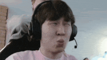 a young man wearing headphones is making a funny face .