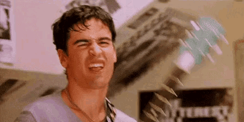 a man is making a funny face while a bunch of papers are falling around him .