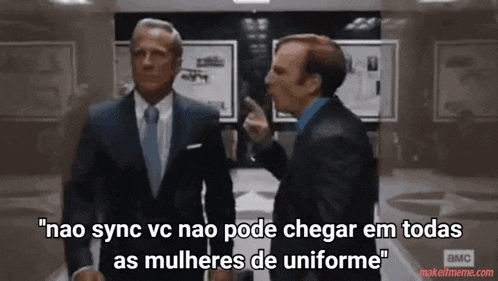 two men in suits and ties are standing next to each other and one of them is pointing at the other