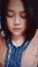 a close up of a woman 's face with her eyes closed and a blue shirt on .