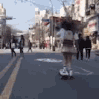 a woman is riding a skateboard down a street in a blurry photo .