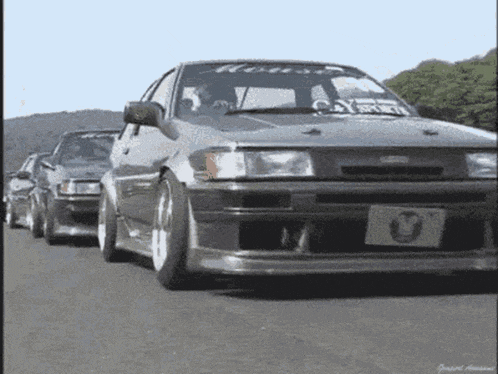 a row of cars are driving down a road with a license plate that says u.