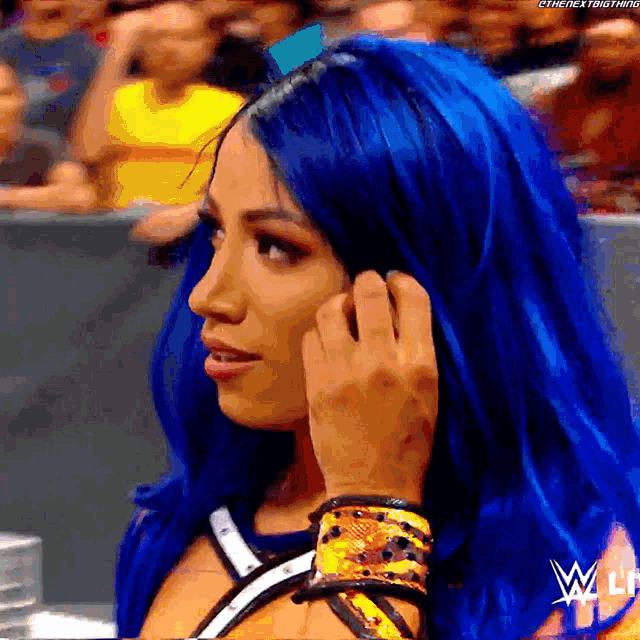 a woman with blue hair is talking on a phone