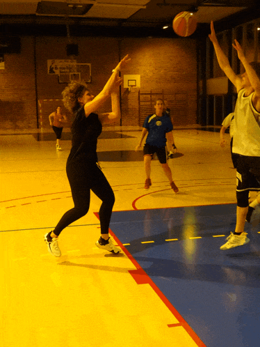 a basketball game is being played on a court with a yellow and blue stripe