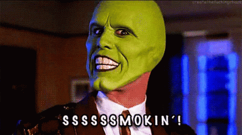 a man in a suit and tie with a green mask on his face