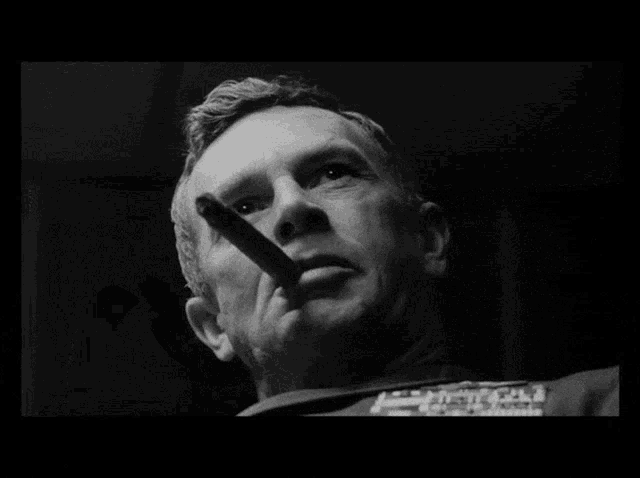 a black and white photo of a man with smoke coming out of his mouth