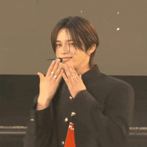 a young man wearing a black jacket and a red shirt with the letter n on it