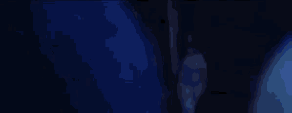 a woman in a white dress is standing in a dark room in the dark .