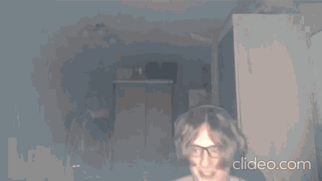 a woman without a shirt is dancing in a dark room with a blurred background .