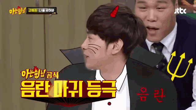 a man in a suit has a devil horn on his head while another man stands behind him