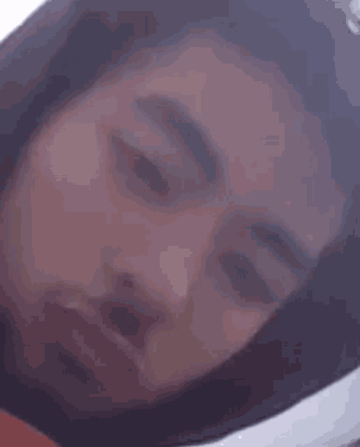 a close up of a man 's face with his eyes closed and his mouth open .