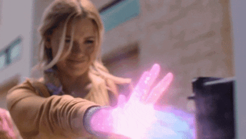 a woman is using her hands to create a purple light .