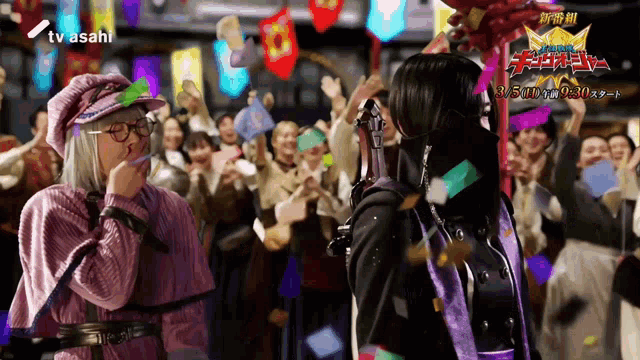 two people are standing in front of a crowd and the tv asahi logo is visible