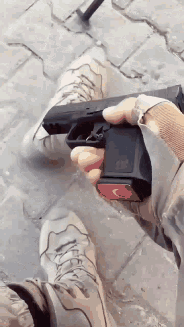 a person is holding a gun with a red c on it