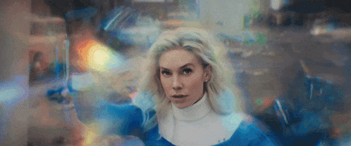 a woman in a blue and white dress is standing in front of a blurry background
